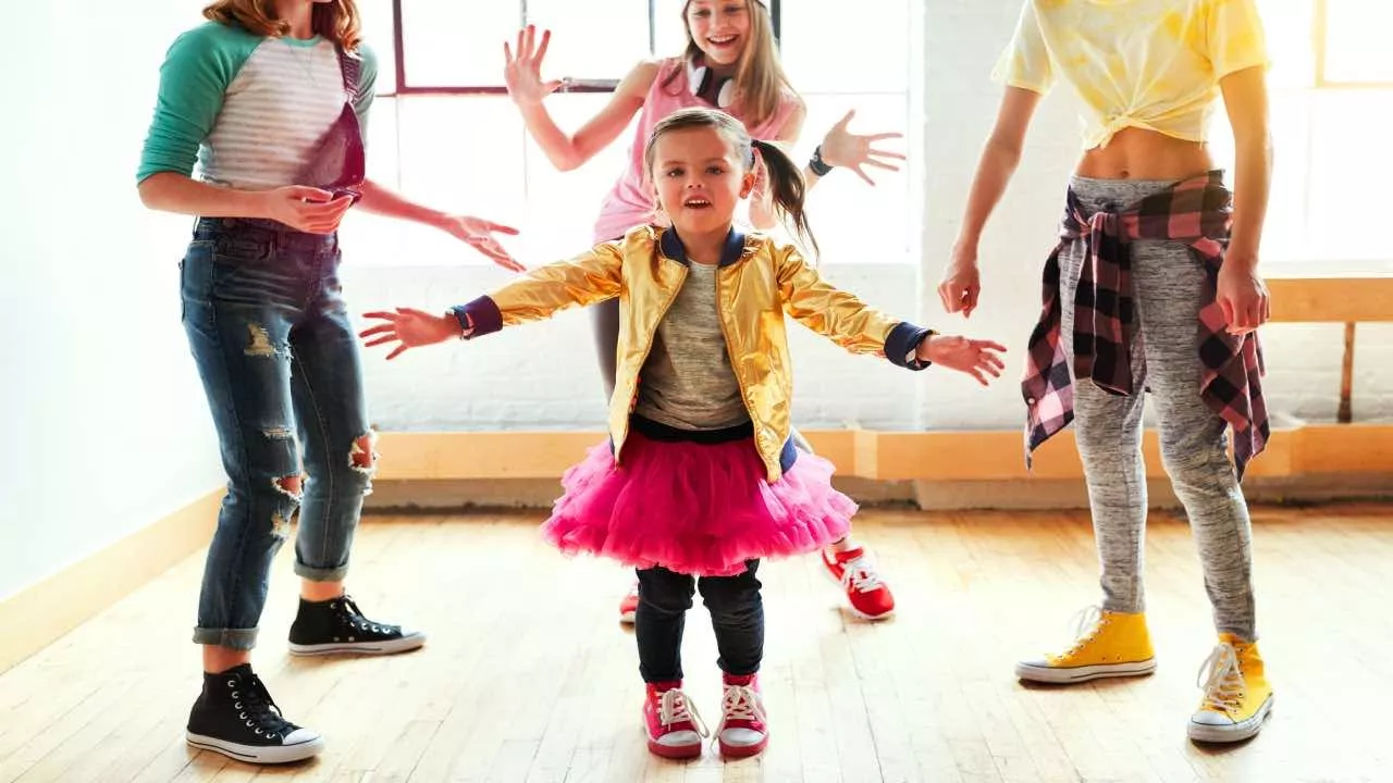 Grupo de niños bailando con alegría en una clase de danza.