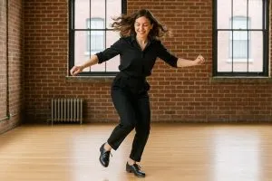 Formación en claqué o tap dance: persona practicando pasos rítmicos con zapatos de claqué.