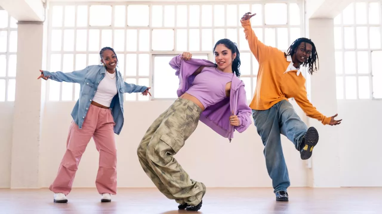 Tres chicas bailando danza urbana con energía y estilo en un espacio moderno.