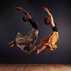 Bailarines de danza contemporánea ejecutando movimientos expresivos en un escenario.