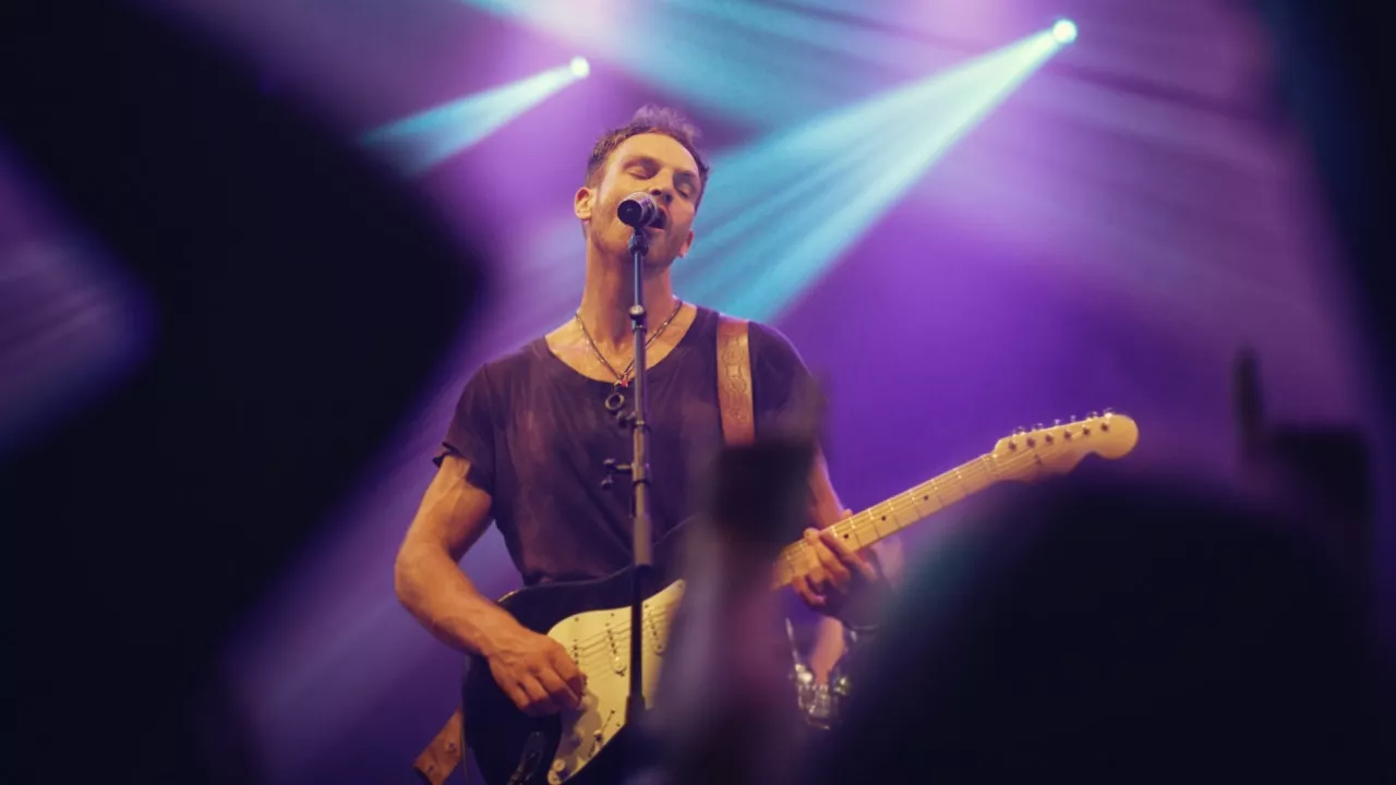 Cantante interpretando una melodía con expresión emotiva, representando la evolución del canto a lo largo de la historia.